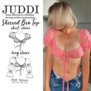 Puede incluir: Un top de sujetador fruncido rosa con mangas cortas y lazo frontal. La imagen también presenta una ilustración de patrón con el texto "JUDDI" y "Shirred Bra Top: short sleeve" y "long sleeve". El patrón está disponible en tallas XXS-3XL y US 0-20.