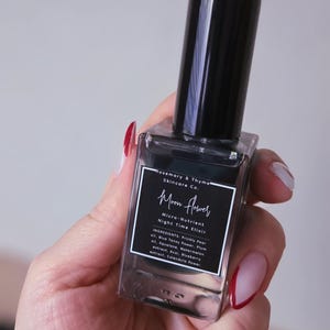 May include: A rectangular glass bottle of Rosemary & Thyme Skincare Co. Moon Flower Micro-Nutrient Night Time Elixir with a black cap. The label lists ingredients including Prickly Pear oil, Blue Tansy flower, Plum oil, Squalane, Watermelon extract, Acai, Blueberry extract, and Calendula flower.