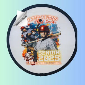 Puede incluir: Un parche redondo blanco con un borde negro. El parche presenta a un jugador de béisbol con un uniforme rojo y blanco con un bate de béisbol. El texto "Congratulations Chad Lewis Senior 2025 Eagles High School" está impreso en amarillo y naranja en el parche.