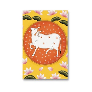 Puede incluir: Una vaca blanca con manchas naranjas se encuentra de pie en un c&iacute;rculo sobre un fondo amarillo con flores de loto rosas. El c&iacute;rculo tiene un borde rojo y puntos naranjas.