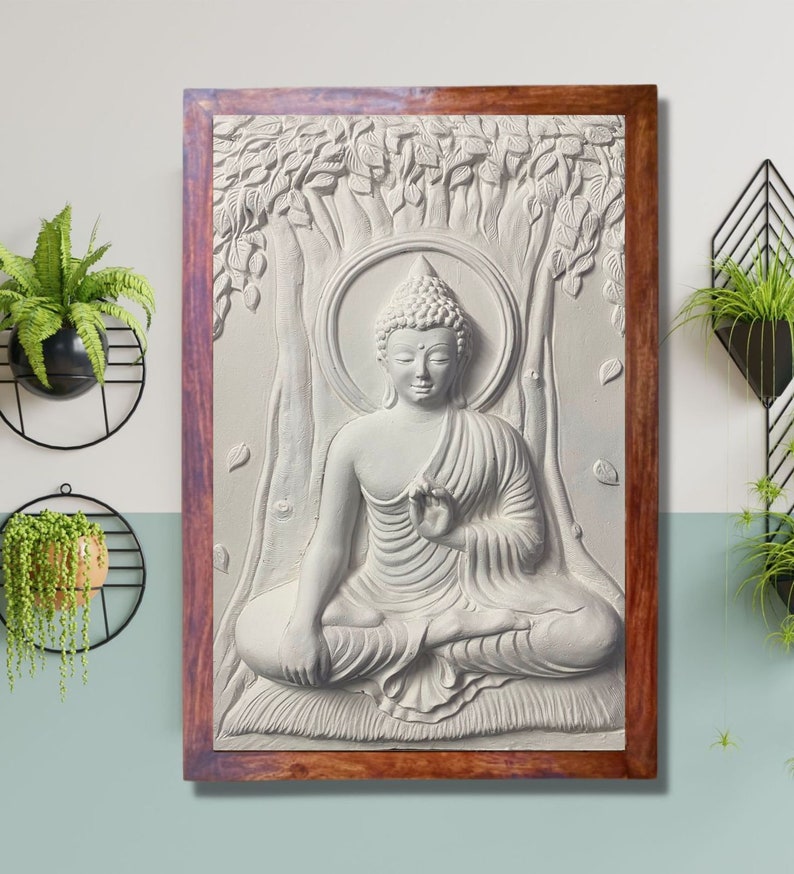 May include: A white, 3D relief sculpture of Buddha sitting in meditation under a tree. The sculpture is framed in a dark wood frame.
