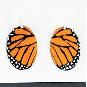 Hand painted monarch butterfly wing oval earrings. Hand made polymer clay earrings.