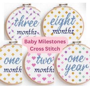 May include: A collection of cross-stitch hoops with baby milestone designs. Each hoop features a different month or year, with text in blue and decorative patterns. The text "Baby Milestones Cross Stitch" is also present.