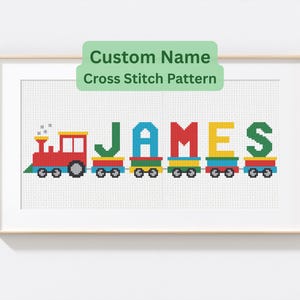 Puede incluir: Patrón de punto de cruz enmarcado con un tren colorido que deletrea el nombre "JAMES". El tren es rojo, amarillo, azul y verde. El texto "Custom Name Cross Stitch Pattern" está encima del tren.