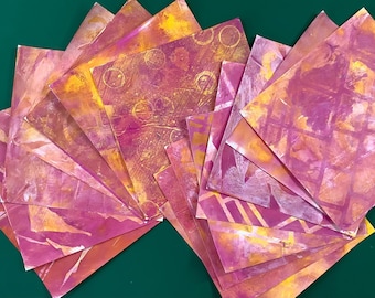 Różowe i żółte papiery kolażowe, odbitki żelowe, albumy ze zdjęciami i projekty artystyczne w technice mieszanej