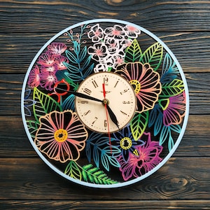 May include: A colorful wooden wall clock with a floral design. The clock face has black hands and Roman numeral markings. The clock is surrounded by a variety of flowers and leaves in shades of pink, blue, green, and yellow.