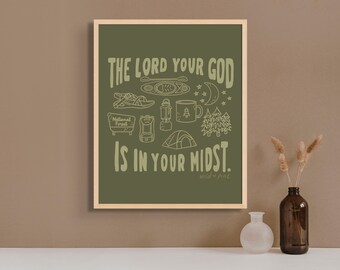 Op de afbeelding: Een groene poster met een witte omtrek van camping- en natuurgerelateerde items, waaronder een tent, een mok, een lantaarn, een kajak en een bord met de tekst "National Forest". De tekst "THE LORD YOUR GOD IS IN YOUR MIDST." is in wit met een groene omtrek geschreven. De tekst "wild + pine" is in wit onderaan de poster geschreven.