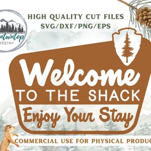 Puede incluir: Un letrero marrón con texto blanco que dice "Bienvenido a la cabaña Disfruta de tu estancia". El letrero tiene un icono de pino verde en la esquina superior derecha. El letrero está sobre un fondo de acuarela con montañas y árboles.