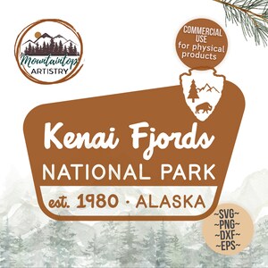 May include: A brown sign with white text that reads "Kenai Fjords National Park est. 1980 - Alaska". The sign is in the shape of a traditional park sign with a mountain range and a bison in the top left corner. The sign is set against a watercolour background of a mountain range with trees.