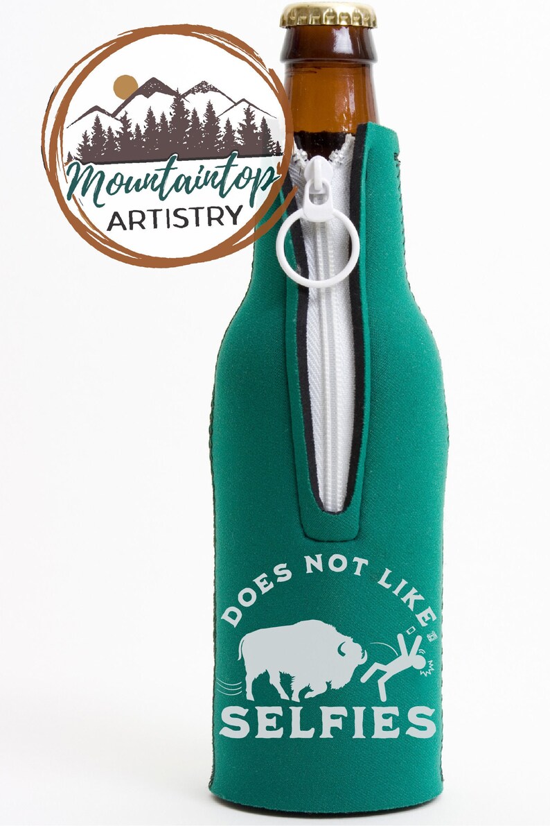 May include: Green zippered bottle cooler with a white buffalo and a stick figure running away from it. The text reads "Does Not Like Selfies".