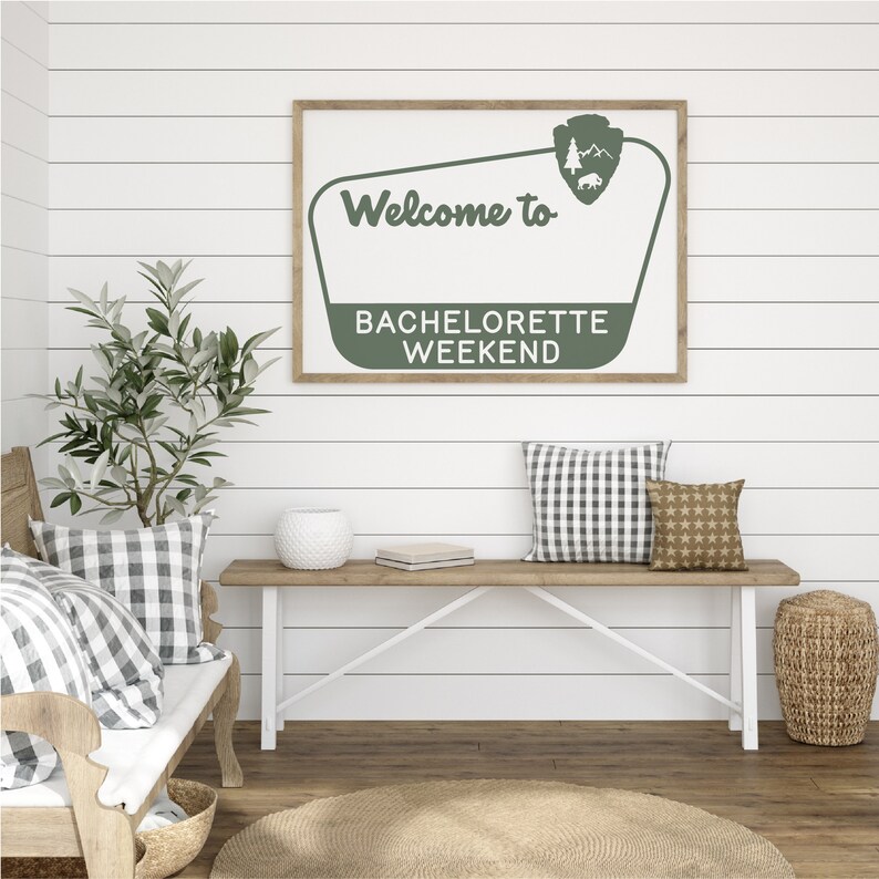 May include: A green and white sign with the text "Welcome to Bachelorette Weekend" in a vintage style. The sign is hanging on a white shiplap wall above a wooden bench with pillows.
