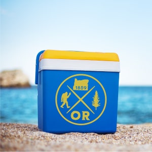 May include: Blue cooler with a yellow lid and a yellow circle graphic. The graphic features a stylised tree, a stylised Bigfoot, and the text "OR 1859".