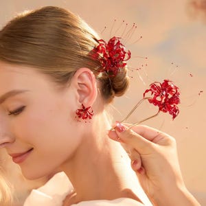 May include: A set of red spider lily accessories including a stud earring and a U-shaped hair pin. The floral pieces feature translucent deep red petals with long, thin, wire-like stamens extending outward, creating a delicate and intricate botanical design.