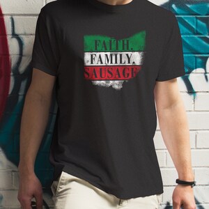 Może przedstawiać: Czarny T-shirt z przetartym wzorem włoskiej flagi. Na fladze widnieje napis "Faith. Family. Sausage."