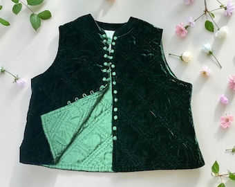 May include: A dark green velvet vest with a quilted lining. The vest has a button-up front with small, round buttons. The exterior features a diamond pattern. The interior lining is a lighter shade of green. The vest is sleeveless.