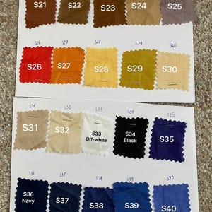 May include: A color chart featuring twenty fabric swatches with pinked edges, labeled S21 through S40. The swatches display a variety of colors including browns, reds, oranges, yellows, beiges, white, black, and various shades of blue and navy.