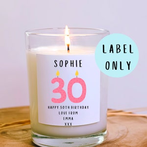 May include: A white candle with a pink and yellow label that says "Sophie 30 Happy 30th Birthday Love from Emma XXX".