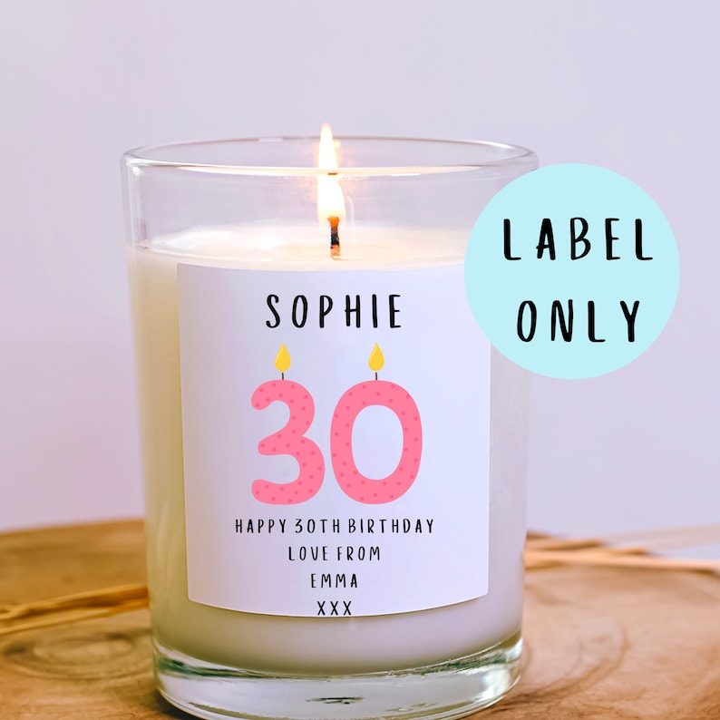 May include: A white candle with a pink and yellow label that says "Sophie 30 Happy 30th Birthday Love from Emma XXX".