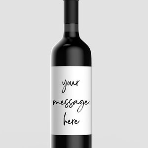 May include: A black wine bottle with a white label that says "your message here".