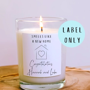 May include: White candle with a label that says "Smells like a new home" and a house with a heart inside. The label also says "Congratulations Hannah and Luke".