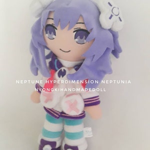 Puede incluir: Mu&ntilde;eca de peluche con cabello lavanda y ojos morados. La mu&ntilde;eca viste una chaqueta blanca con detalles rosas, una falda a rayas morada y azul, y leggings a rayas a juego. El texto en la imagen dice "NEPTUNE HYPERDIMENSION NEPTUNIA NYONGKIHANDMADEDOLL."