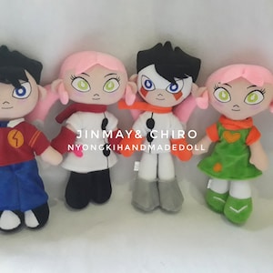 May include: Four plush toys, two pink-haired female characters and two male characters with black hair. The female characters are wearing dresses and the male characters are wearing shirts and trousers. The text "JINMAY & CHIRO NYONGKIHANDMADEDOLL" is visible in the image.