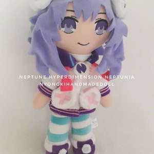 Puede incluir: Mu&ntilde;eca de peluche hecha a mano de un personaje de la serie Neptunia. La mu&ntilde;eca tiene cabello morado, un atuendo blanco y morado y leggings a rayas azules y blancas. El texto "NEPTUNE HYPERDIMENSION NEPTUNIA NYONGKIHANDMADEDOLL" est&aacute; impreso en la imagen.