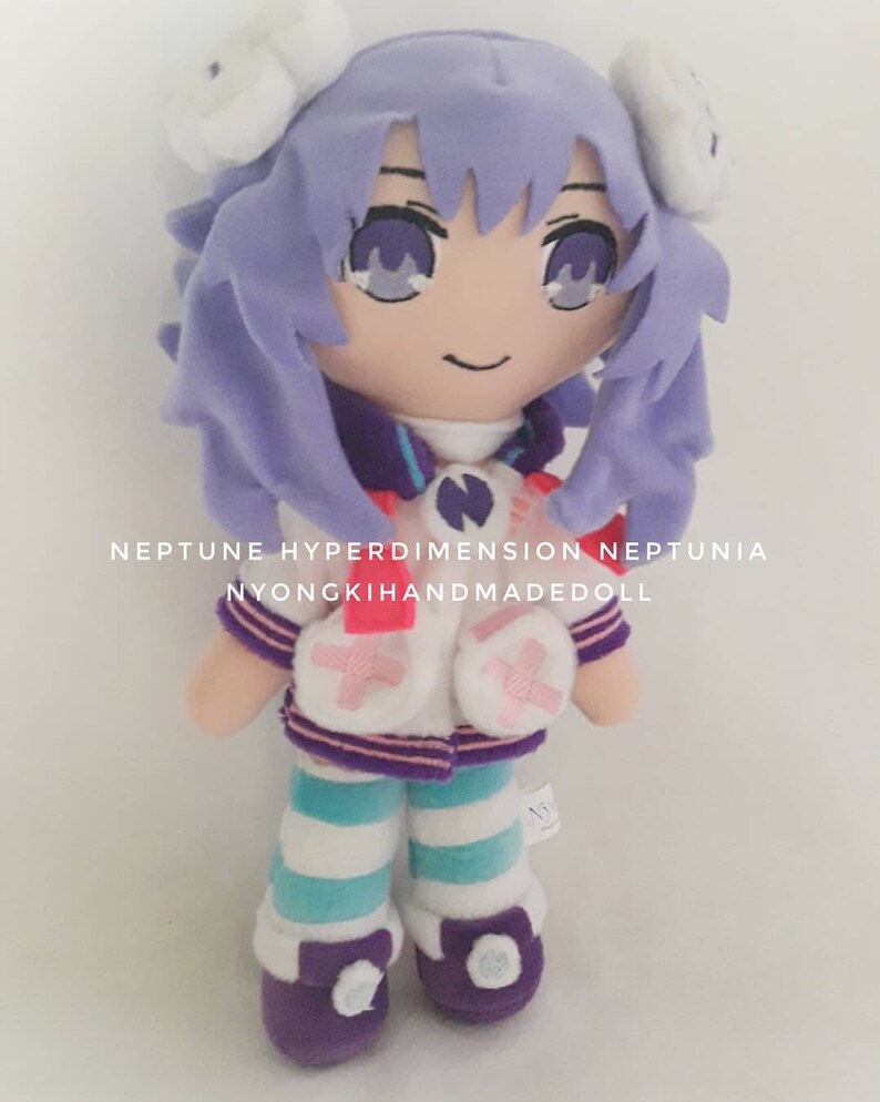 Puede incluir: Mu&ntilde;eca de peluche hecha a mano de un personaje de la serie Neptunia. La mu&ntilde;eca tiene cabello morado, un atuendo blanco y morado y leggings a rayas azules y blancas. El texto "NEPTUNE HYPERDIMENSION NEPTUNIA NYONGKIHANDMADEDOLL" est&aacute; impreso en la imagen.
