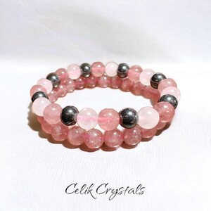 Può includere: Un braccialetto a doppio filo con perline rosa e argento. Il braccialetto è realizzato con perline di quarzo rosa ed ematite.