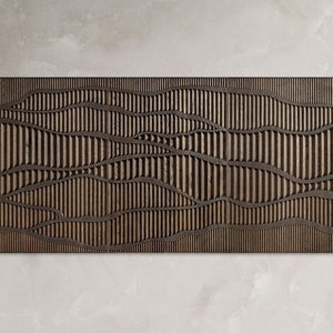 Può includere: Un pannello da parete in legno marrone con un motivo geometrico di linee verticali e curve ondulate. Il pannello è in legno e ha una finitura naturale.