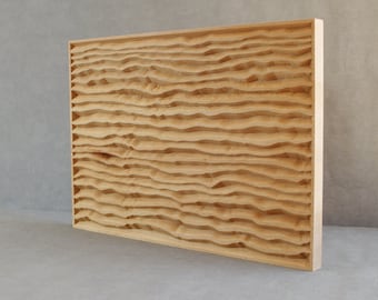 May include: A light brown wood panel with a carved wavy pattern. The panel is rectangular and has a smooth, polished surface.