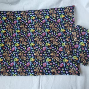 May include: Two black fabric bags with a colourful, repeating pattern of cartoon dogs and flowers. The bags have a drawstring closure.