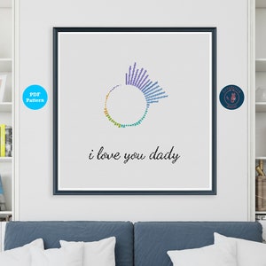 Op de afbeelding: Een zwart ingelijst afdruk met een kleurrijk cirkelontwerp en de tekst "i love you daddy".