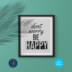 May include: A black framed picture with a white background and the text "dont worry be happy" in black.