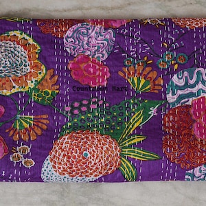 May include: A rectangular, quilted textile with a vibrant floral pattern. The design features large flowers in shades of orange, pink, and green against a deep purple background. The text "Countdown Mart" is visible. White stitching outlines the floral elements.
