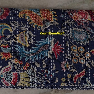 Peut inclure: Textile pli&eacute; bleu marine avec un motif floral rouge, jaune, bleu et vert. Le textile pr&eacute;sente des coutures blanches et un bord festonn&eacute;. Le texte "CountDownMart" est visible.