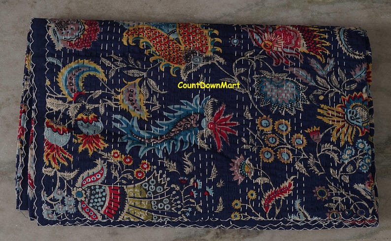 Peut inclure: Textile pli&eacute; bleu marine avec un motif floral rouge, jaune, bleu et vert. Le textile pr&eacute;sente des coutures blanches et un bord festonn&eacute;. Le texte "CountDownMart" est visible.