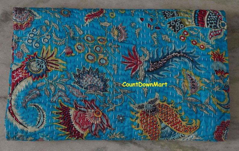 Peut inclure: Textile turquoise rectangulaire avec un motif floral rouge, jaune et orange. Le motif comprend des fleurs et des feuilles stylis&eacute;es, avec des coutures blanches. Le texte "CountDownMart" est visible.