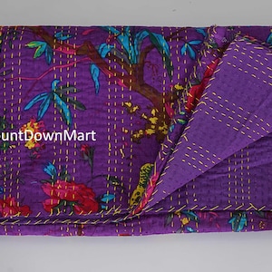 May include: A folded purple quilt with a floral pattern in red, teal, and yellow. The quilt is stitched with gold thread and has a solid purple reverse side. The text "CountDownMart" is visible on the quilt.