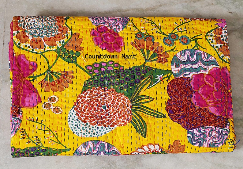 May include: A yellow textile with a vibrant floral pattern. The design features large flowers in shades of pink, orange, and green, with intricate detailing. The text "Countdown Mart" is visible. The textile is likely a decorative item.