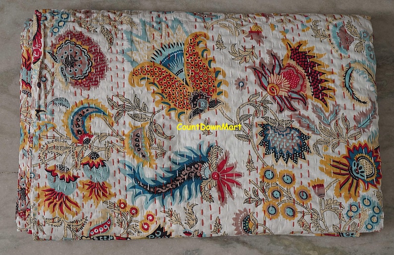 Peut inclure: Une courtepointe blanche avec un motif floral color&eacute;. Le motif pr&eacute;sente de grandes fleurs stylis&eacute;es dans des tons de rouge, jaune, bleu et marron, avec des d&eacute;tails et des coutures complexes. Le texte "CountDownMart" est visible.