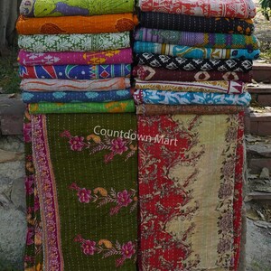 May include: A stack of colourful kantha quilts with floral and geometric patterns. The quilts are folded and stacked on top of each other, creating a visually appealing display. The text "Countdown Mart" is visible on the bottom of the image.