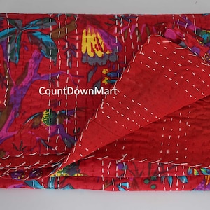 May include: A red, floral-patterned quilt with white stitching. The quilt features a vibrant design with purple, yellow, and blue accents. The text "CountDownMart" is visible on the quilt. This handmade quilt is perfect for adding a touch of color to any bedroom.
