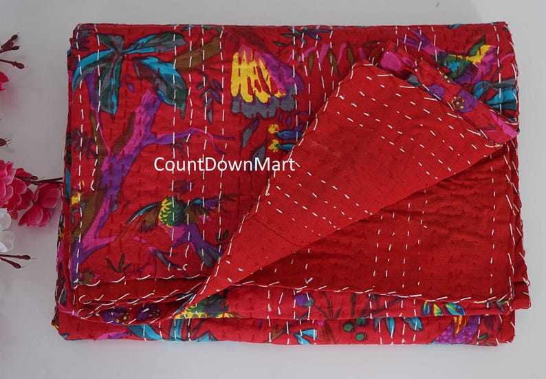 May include: A red, floral-patterned quilt with white stitching. The quilt features a vibrant design with purple, yellow, and blue accents. The text "CountDownMart" is visible on the quilt. This handmade quilt is perfect for adding a touch of color to any bedroom.