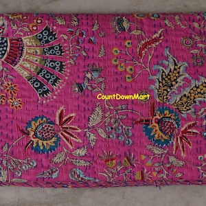 Peut inclure: Textile magenta pli&eacute; avec un motif floral et cachemire d&eacute;taill&eacute;. Le motif comprend des accents bleus, jaunes et rouges. Le texte "CountDownMart" est visible sur le tissu.