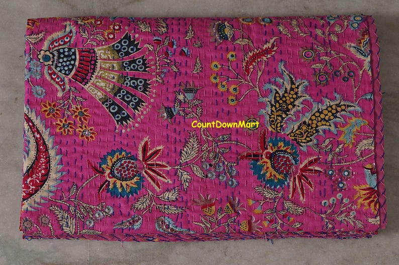 Peut inclure: Textile magenta pli&eacute; avec un motif floral et cachemire d&eacute;taill&eacute;. Le motif comprend des accents bleus, jaunes et rouges. Le texte "CountDownMart" est visible sur le tissu.