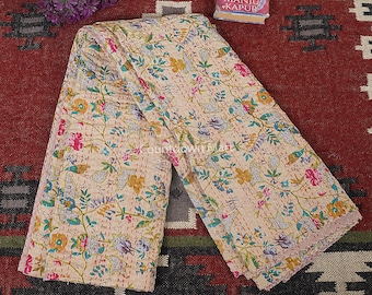May include: A beige kantha quilt with a floral print in shades of pink, yellow, blue, and green. The quilt is folded in half and has a hand-stitched design.