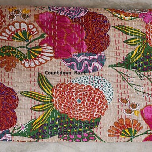 Pode incluir: Um edredom floral bege com um design vibrante. O edredom apresenta grandes flores estilizadas em tons de rosa, laranja e verde, com costuras intrincadas. O texto "Countdown Mart" é visível.