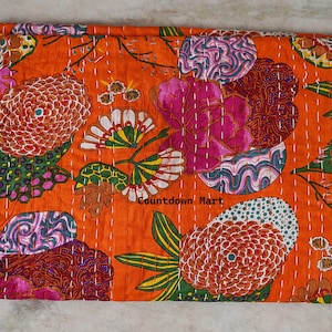 May include: An orange floral patterned quilt with large flowers in shades of pink, white, and red. The quilt has a stitched design and the text "Countdown Mart".