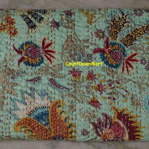 May include: A light teal quilt with a floral pattern in red, yellow, blue, and brown. The quilt features a repeating design of large flowers and paisley shapes, with the text "CountDownMart" visible.